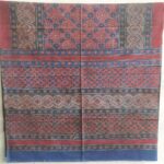 rich maroon cotton ajrakh bedsheet styled on bed traditional design