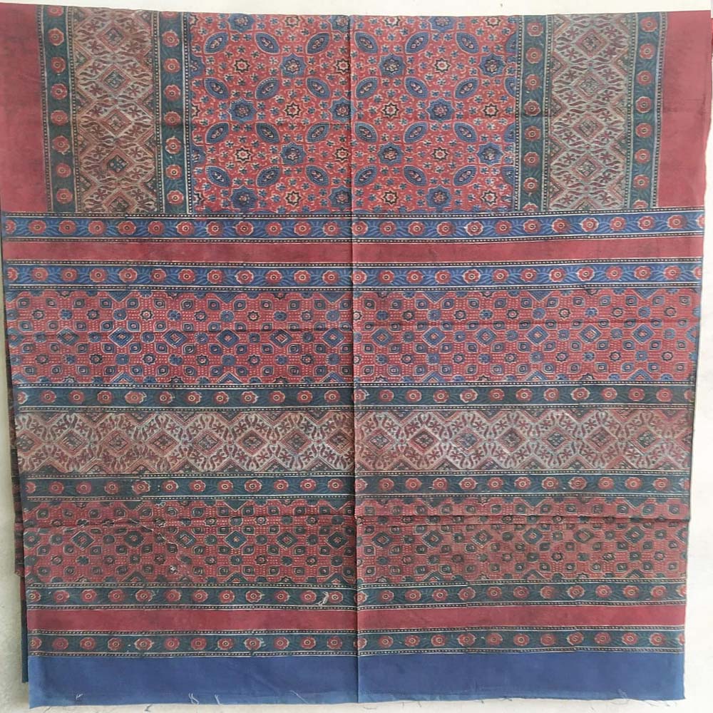 rich maroon cotton ajrakh bedsheet styled on bed traditional design