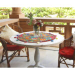 Stunning Barmer green round table runner close-up displaying handcrafted cotton embroidered patchwork with floral and leaf designs, tassels, and textured details