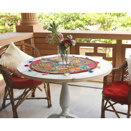 Stunning Barmer green round table runner close-up displaying handcrafted cotton embroidered patchwork with floral and leaf designs, tassels, and textured details